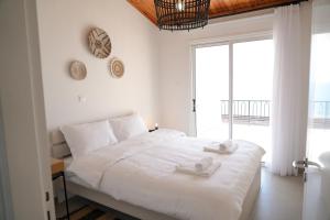 拉纳卡Meneou Houses by the Sea的白色的卧室设有一张大床和一个大窗户