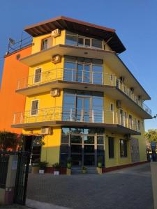 维利波吉Hotel PRINC的黄色的建筑,旁边设有阳台