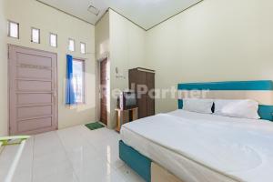 BanjarbaruAna Guest House Syariah Mitra RedDoorz的一间卧室设有一张大床和一扇门