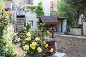 恰纳卡莱Gallipoli Dublex House的种着黄色花卉的花园,鸟舍