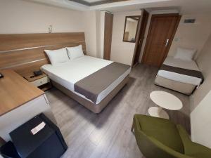 锡瓦斯BEYAZ İNCİ OTEL的酒店客房配有一张床、一张桌子和一把椅子。