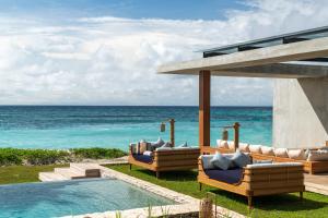 Cap Karoso Sumba - a member of Design Hotels的一个带游泳池和椅子的度假胜地和大海