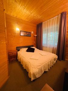 BērzciemsTAURIŅI的木制客房内的一间卧室,配有一张床