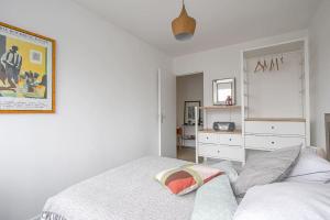 凯恩Appt agréable avec balcon au sud-ouest de Caen的一间白色卧室,配有一张床和一个梳妆台