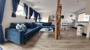 坎珀兰Vakantiehuis de Ankerplaats的客厅配有蓝色的沙发和桌子