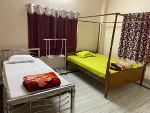 阿加尔塔拉Vamoose S Das Homestay的一间卧室配有两张床和一张天蓬床。