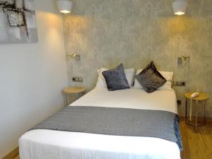 巴塞罗那略雷特兰布拉酒店的卧室配有白色的床和2个枕头