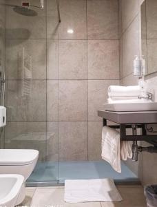 米兰中央车站酒店的带淋浴、卫生间和盥洗盆的浴室