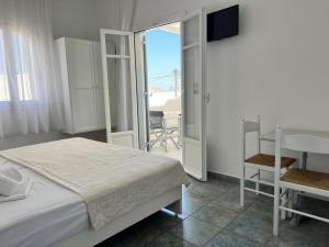 纳乌萨瓦瓦诺斯公寓的一间卧室配有一张床铺和一张桌子,并设有一个阳台