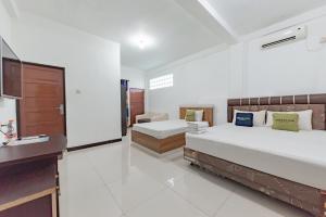 MartapuraUrbanview Hotel 99 Syariah Banjarbaru by RedDoorz的一间大卧室,配有两张床和盥洗盆