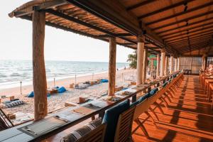 象岛Kacha Resort & Spa, Koh Chang - SHA Extra Plus的海滩上的餐厅,配有桌椅