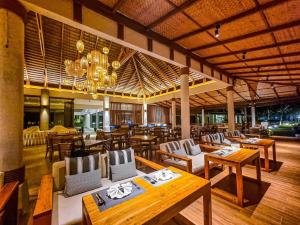 象岛Kacha Resort & Spa, Koh Chang - SHA Extra Plus的餐厅设有木桌、椅子和吊灯。