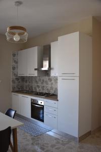 泰尔莫利Russo Apartment的厨房配有白色橱柜和白色冰箱。
