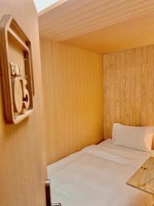 莱卡邦博克斯特曼谷机场胶囊旅馆的一间小卧室,卧室内配有一张床铺