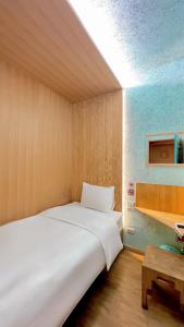 莱卡邦博克斯特曼谷机场胶囊旅馆的一张大白色的床,位于带桌子的房间