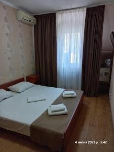 基辅拉玛2号酒店的一间卧室配有一张床,上面有两条毛巾