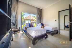 BanjarVilla Akasa Segara Beachfront and Private Pool的一间卧室配有两张床、一台电视和镜子
