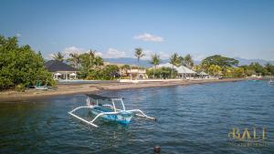 BanjarVilla Akasa Segara Beachfront and Private Pool的坐在海滩旁的水面上的船