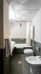 梅里达宙斯酒店的浴室配有盥洗盆、卫生间和浴缸。