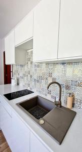 鲁特罗Apartamenty Harnaś的白色的厨房配有水槽和白色橱柜