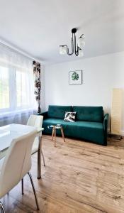 鲁特罗Apartamenty Harnaś的客厅配有绿色沙发和桌子