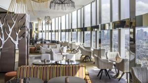 巴黎巴黎星辰广场凯悦酒店的餐厅设有桌椅和大窗户。