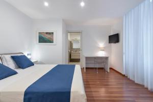 莱切Suite San Biagio的卧室配有蓝色和白色的床和电视。