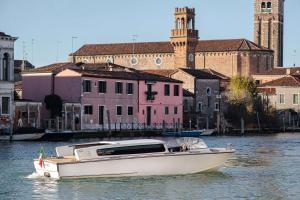 穆拉诺Hyatt Centric Murano Venice的建筑物前水面上的白色船