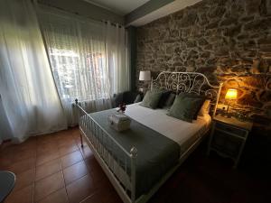 莫利纳塞卡Hostal Casa San Nicolas的一间卧室设有一张床和石墙