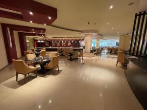 拉斯阿尔卡麦I Like Al Hamra Palace - Elite Beach & Golf Resort Private Suites的一间带桌椅的餐厅和一间酒吧