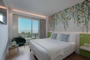 西尔米奥奈Olivi Hotel & Natural Spa的一间卧室设有一张床和一个大窗户