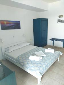 阿佐里姆诺斯Aigaio studios & rooms的一间卧室配有一张带蓝色橱柜的床和一张桌子