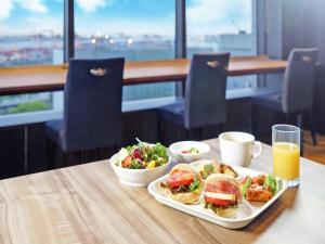 东京品川海滨罗伊斯酒店的一张桌子,上面放着三明治、沙拉和橙汁
