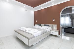乌尔齐尼Apart-Hotel President的卧室配有一张白色的大床和一张沙发。