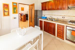 博卡奇卡Hotel Villa Capri的厨房配有木制橱柜和白色桌子。