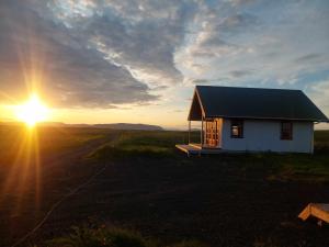 塞尔福斯Hólar countryside cabin 1的落日时在田野的小房子