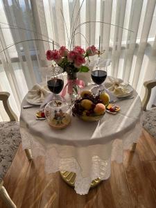 埃里温Nork Hotel的一张桌子,上面放着酒杯和水果,花朵