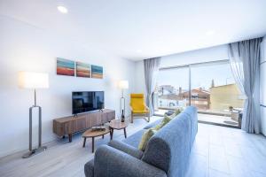 布尔高The Hub central apartment Burgau的客厅配有蓝色的沙发和电视