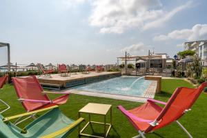贝拉里亚-伊贾马里纳萨维尼酒店的一组椅子和一个带桌子的游泳池