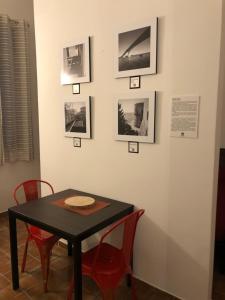 塔兰托Downtown Lodge Museum的一张桌子、红色的椅子和墙上的照片
