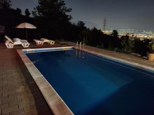 萨拉热窝Bungalovi Lana的享有城市美景的夜间游泳池