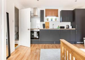 伦敦Modern Studio Apartment In Shoreditch的厨房铺有木地板,配有灰色橱柜。