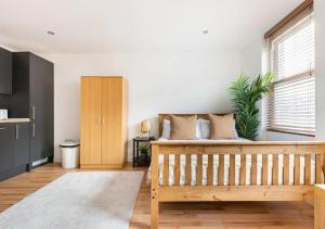 伦敦Modern Studio Apartment In Shoreditch的一间卧室设有一张木床和一个窗户。