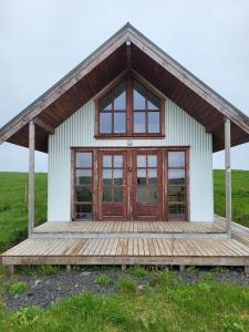 塞尔福斯Hólar Countryside Cabin 2的一座小房子,在田野上设有木甲板