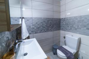 马克里亚罗斯Palm home 1的浴室配有白色卫生间和盥洗盆。