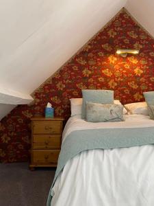 RoughtonBarnacle Barn, North Norfolk的一间卧室设有两张床和鲜花墙