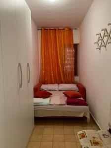 斯卡莱阿Appartamento Gabbiano的一间小卧室,配有带橙色窗帘的床