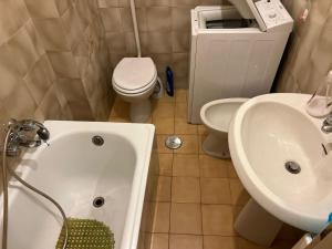 斯卡莱阿Appartamento Gabbiano的浴室配有卫生间、浴缸和水槽。