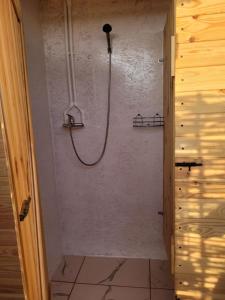旧瓦马Makeeda Camping的浴室内墙上的软管淋浴