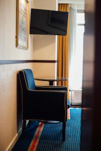 格罗宁根Boutique Hotel De Doelen的酒店客房设有椅子和桌子